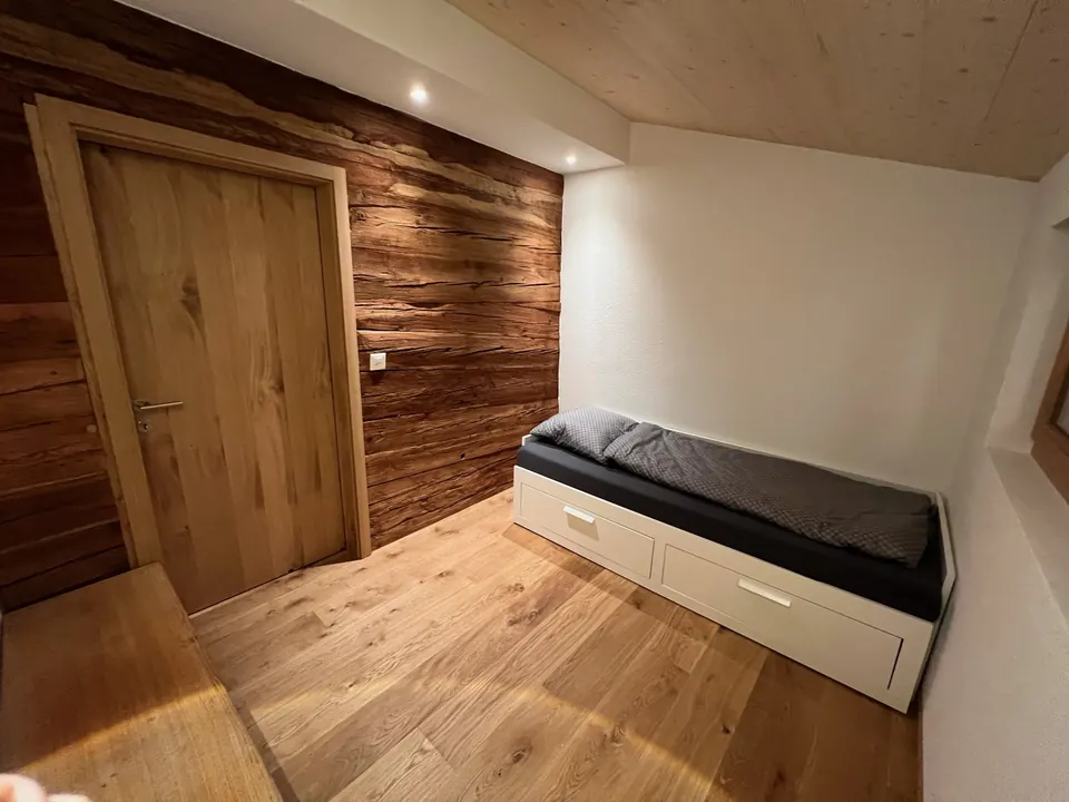 Dachgeschoss · Zimmer 2 mit Altholzwand und ausziehbarem Doppelbett